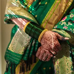 The traditional 'Hirva Chuda' or green bangles, an essential part of a Marathi bride's attire. Paired with her henna-stained hands, it's a beautiful symbol of her new journey.