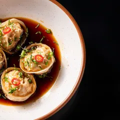 Delicate cottage cheese tortellini dumplings are served in a rich, savoury soy broth and garnished with fresh chillies and herbs. A truly impressive start to any meal.