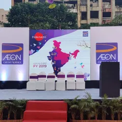 A clear view of a stage I designed for the AON Credit Service annual event. The setup features a large, high-resolution LED screen for presentations, flanked by branded panels, demonstrating how I integrate corporate identity directly into the main focal point of an event.