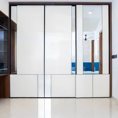 This Aristo wardrobe with high-gloss white panels and subtle mirror details enhances both form and function. The sliding doors glide with ease, maximizing space and light.