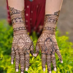 A classic engagement design featuring interlocking rings on one palm and the couple's initials on the other, set against a backdrop of lush greenery.