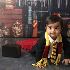 On the move in the magical world. This crawling shot captures the curiosity of a one-year-old exploring the detailed Harry Potter set, from the vintage clock to the tiny suitcase prop.