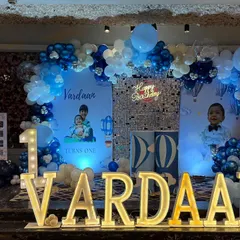 A full view of Vardaan's birthday stage, with large marquee letters and a light-up number '1'.