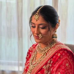 A close-up of my soft glam technique on a bride wearing a traditional red wedding outfit. The focus is on luminous skin, subtly defined eyes, and a lip color that enhances her natural tone.
