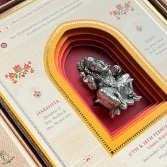A beautifully crafted wedding invitation featuring a 3D layered archway and a silver Ganesha idol. The first impression of your wedding starts here, and we collaborate with top designers to create something truly special.