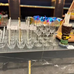 Every detail matters. Our bar setups feature premium glassware, like these champagne flutes garnished with orchids, alongside custom-branded stirrers to add a personalized touch of elegance.