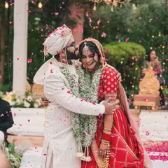 Pure, unscripted joy. A candid shot of the couple embracing under a shower of petals right after the ceremony, capturing a memory that is both beautiful and real.