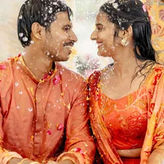A beautiful moment between the couple during their Haldi, as they are showered with water and flower petals.