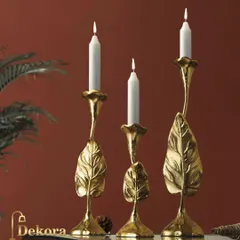 This set of three candle stands features a nature-inspired leaf motif crafted from cast metal with a gold finish. Their organic shape adds an artistic and elegant touch to a console table or dining centerpiece.