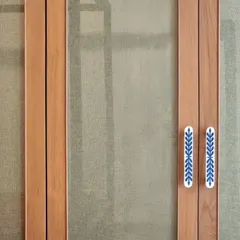 Custom door handles with a delicate blue and white ceramic inlay. These details are an opportunity to introduce craft and color at a human scale, making everyday interactions with the space more delightful.