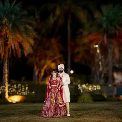 A stunning wide shot of the bride and groom on their wedding night. The beautifully lit palm trees create a magical, resort-wedding atmosphere.
