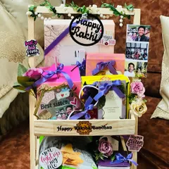 A grand, two-tiered wooden stand hamper for a sister, personalized with photos and "Best Sister" tags. It's packed with her favorite snacks, accessories, and treats.