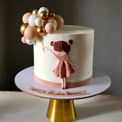 A simple and elegant cake featuring a 2D bas-relief style girl holding a bouquet of balloons. The clean white buttercream and the monochrome color palette give this design a very modern and sophisticated feel.