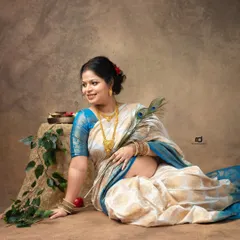 A serene portrait of a mom-to-be in a beautiful silk saree, holding a peacock feather. This pose is rich with cultural symbolism and timeless elegance.