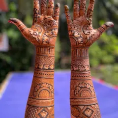 This full-coverage bridal mehendi showcases a beautiful blend of geometric and floral patterns. The design flows symmetrically up both arms, creating a balanced and traditional look.