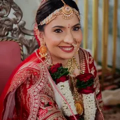 A close-up of this radiant bride. Her classic look features a red bindi, traditional matha patti, and a smile that shines, perfectly framed by her varmala.