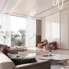 This living space is designed for a continuous flow of light and air. The floor-to-ceiling windows connect the interior to a green terrace, while the soft, neutral tones and modern lighting create a calm and welcoming atmosphere.