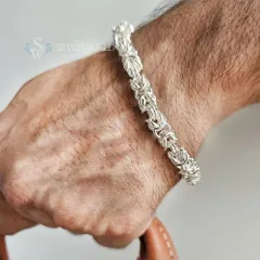 For a bolder statement, we present the King's Chain bracelet. This design features a complex, interlocking weave of pure 92.5 silver, creating a substantial piece that signifies strength and intricate craftsmanship.