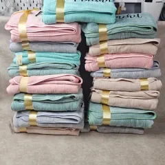 We prepared this bulk order of premium ribbed towels, each personalized with a name and tied with a gold ribbon, for a special event.
