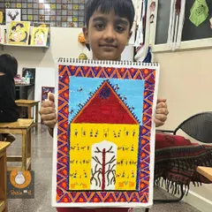 At just six years old, our students are already exploring rich cultural art forms. This young artist proudly holds his detailed Saura tribal art piece, a style from Odisha that teaches storytelling through intricate patterns and shapes.