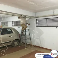 Here, our installer is running wires along the ceiling conduit in a parking area. This meticulous approach to wiring ensures the system is both reliable and aesthetically pleasing.