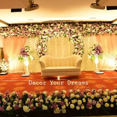 We create elegant stages for receptions and engagements. This classic design features a blush pink and white floral arch, soft drapery, and grand pillars to create a romantic and sophisticated atmosphere.