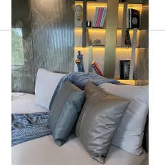 A close-up of our custom leather cushions against an artfully designed, illuminated bookshelf. Even the smallest details are considered to complement the larger wall treatments and furniture.