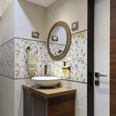 A wider view of the wash area, showing the decorative mirror and the floral tile band. This space, though compact, is designed with a high level of detail and artistry.