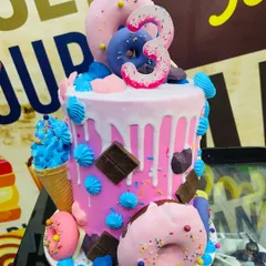 A 3kg donut and ice cream-themed cake, bursting with color, sprinkles, and sweet treats.