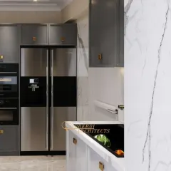 A view of the integrated appliances, including a side-by-side refrigerator and built-in ovens, which create a seamless and high-end look.