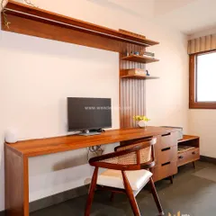 A larger study and media unit in the same earthy-themed home, with a long wooden desk, drawers, and open shelving for a complete workstation.
