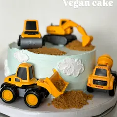 A construction-themed cake for a little builder. This is a completely vegan cake, decorated with fun toy trucks and edible "dirt" for a memorable birthday.