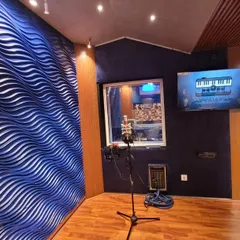 This is our vocal booth, equipped with a professional condenser mic to capture every detail of your performance. The window connects you to the control room, making communication with the engineer seamless.