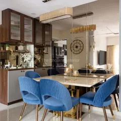 This dining space from 'The Adobe' project was designed to feel both grand and intimate. The deep blue upholstered chairs provide a rich pop of color against the Italian marble tabletop, while the mirrored wall cladding visually expands the space, creating an elegant setting for memorable meals.