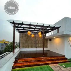 The final result of a rooftop transformation project, featuring a covered seating area under a new pergola, a polished wooden deck, and a lush green lawn space.