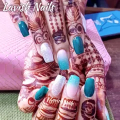 This design shows how beautifully colored nails can complement bridal mehendi. The set combines solid teal, white glitter, and a soft teal-to-nude ombré for a vibrant, photo-ready look.