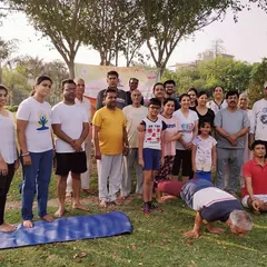 This is what our community looks like. We bring together people of all ages, from young children to seniors, for our outdoor yoga sessions in the park. Here I am demonstrating Mayurasana (Peacock Pose) for the group.