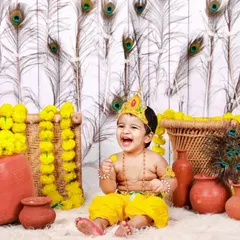 The joyful laughter of little Krishna! This Janmashtami setup is filled with bright colors, peacock feathers, and clay pots, creating a lively and festive scene.