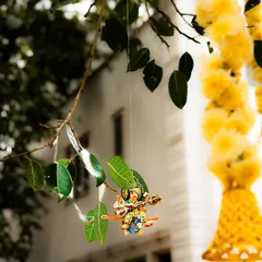 A tiny, hand-painted figurine of a deity playing a veena hangs delicately from a tree branch. These whimsical touches are part of my styling philosophy, adding a layer of charm and discovery to an event space.
