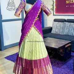 The full view of a custom Pattu Langa Davani on a mannequin. This shows how the heavily embroidered blouse and dupatta complement the pleated silk skirt with its traditional border.