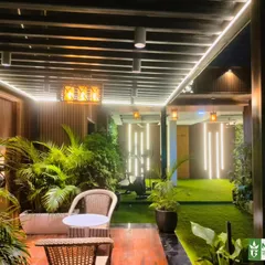 An evening shot of the Model Town terrace, highlighting the vertical LED tube lights and pendant lamps that create a dramatic and modern atmosphere.