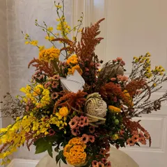 A magnificent ballet of browns, offset by vibrant and whimsical yellow Oncidium orchids. This autumn tablescape uses the unique texture of Banksia to create a chic and sophisticated arrangement.