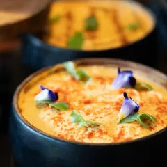 A creamy, rich dip garnished with edible flowers and spices. This dish brings the comforting, authentic flavors of India to a wedding celebration in a refined and beautiful way.