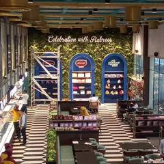 A high-angle view of a sweet shop, "Celebration with Rabrees," where we installed a large green wall as a backdrop for their display shelves.