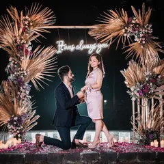 The magical moment of the proposal, framed by our boho-chic floral arch and the warm glow of a custom neon sign.