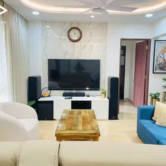 This living room setup features a pair of powerful floor standing speakers alongside a large TV. This combination provides a significant audio upgrade for movies, music, and daily viewing, integrating seamlessly with the room's decor.