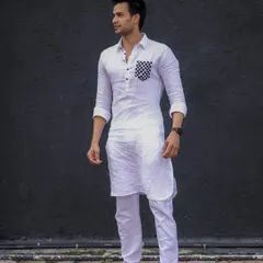 A modern twist on a classic. This crisp white linen kurta features a bold, checkered pattern on the pocket, offering a unique and stylish statement.