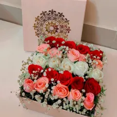 An elegant square box overflowing with a mix of red, pink, and white roses, accented with baby's breath. This sophisticated arrangement is perfect for any celebration, from Rakhi to anniversaries.
