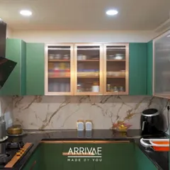 This U-shaped kitchen makes a bold statement with its rich green cabinetry and elegant rose gold accents. The design is perfectly balanced with a white marble-patterned backsplash and a dark quartz countertop, showcasing a luxurious yet functional space.