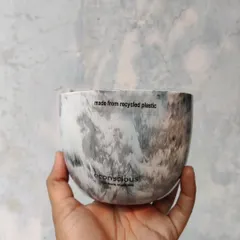 A close-up of our grey marble finish planter, held in hand to show its detail. Each pot is proudly marked 'made from recycled plastic' as a reminder of its sustainable origins.